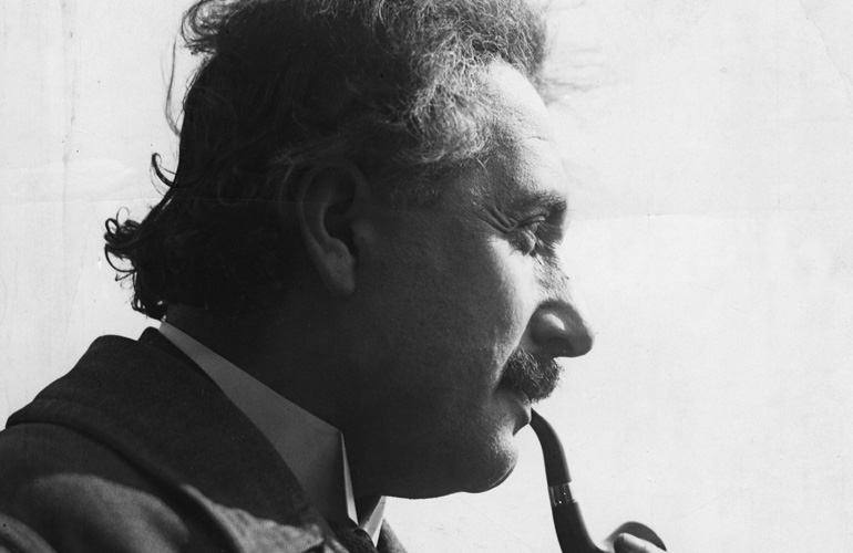 Albert Einstein raucht Pfeife.