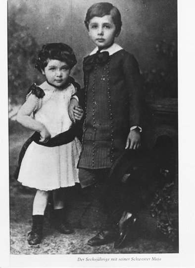 Ein Mädchen und ein Junge stehen Hand in Hand nebeneinander.