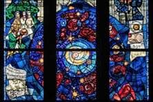 Ein Kirchenfenster zeigt verschiedene, aus Glassteinen zusammengesetzte Motive, unter anderem die fünf Wissenschaftler Kopernikus, Kepler, Galilei, Newton und Einstein.